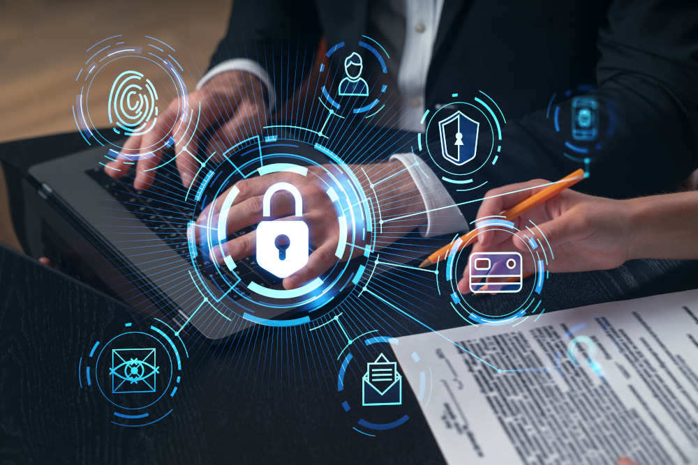 Professionals working on laptops with holographic cybersecurity icons overlaid, including a padlock, fingerprint, shield, and secure email symbols